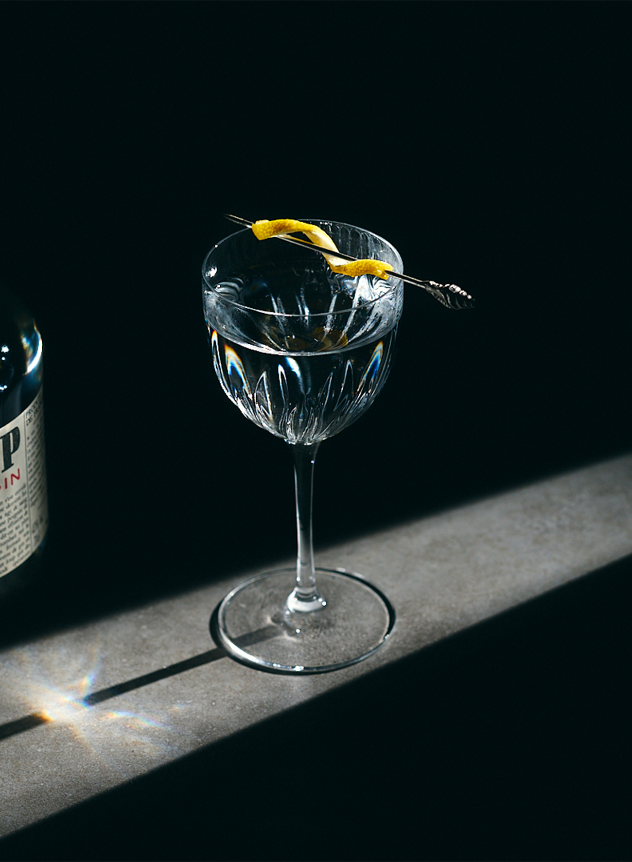 Une photo de gin tonic avec un faisceau lumineux dessus, cocktail à base de gin Hold Up